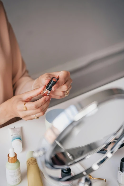 a woman is standing by her mirror and holding a cellphone