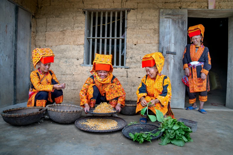 five young people in orange ethnic outfits cooking