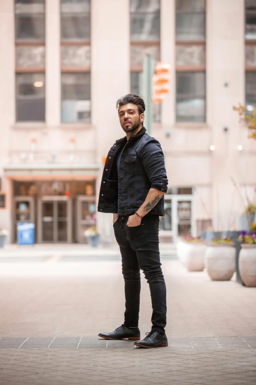 a man is standing in a square with a black jacket