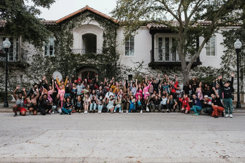 a group of people gathered on the front lawn of a building