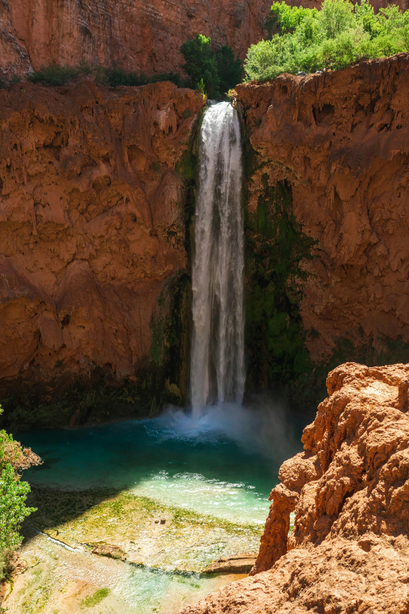 this picture is of the waterfall and pool at the base of a canyon