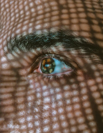 a blurry close - up image of a mans eye with a very large blue - green eye