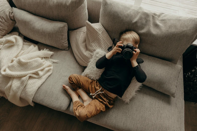 small child playing with a camera in the living room