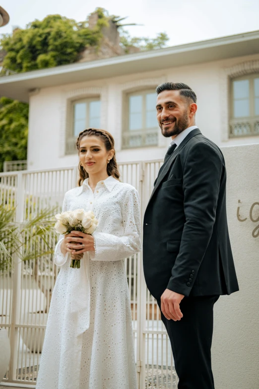 a man and woman holding flowers standing near each other