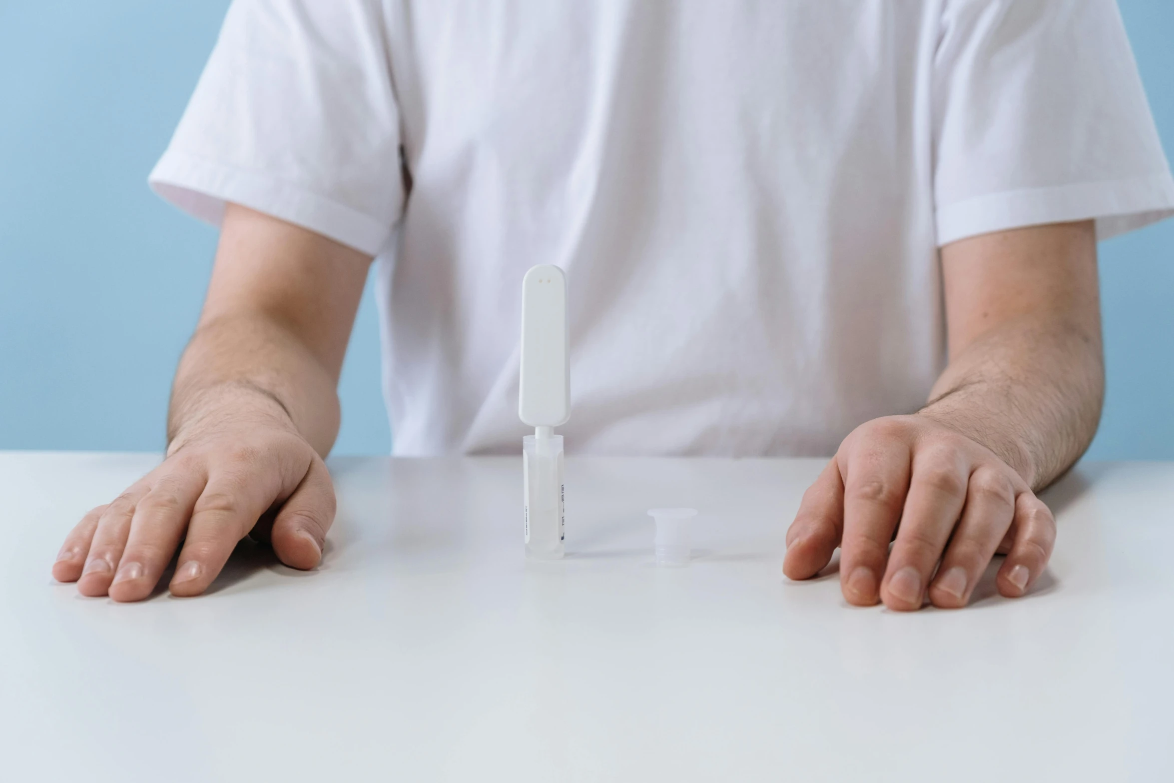 a man sits at a table in front of a white object