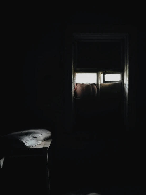 a chair that is in the dark by a window