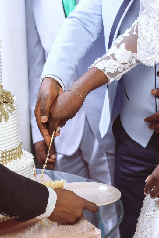 people standing around one another  a wedding cake