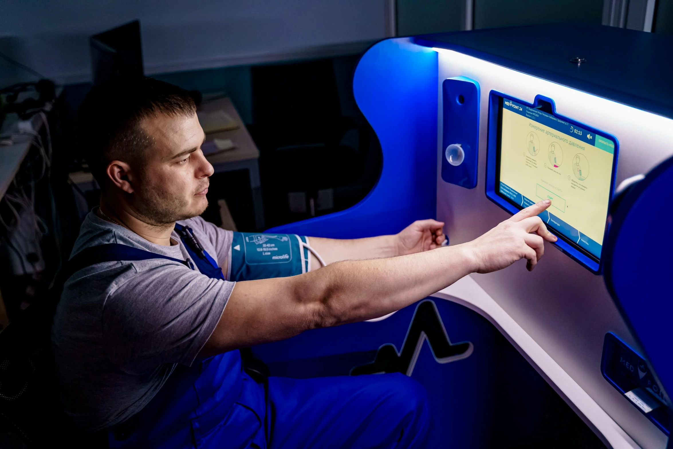 man in blue uniform pointing to screen on display