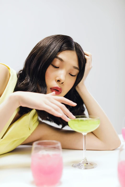 a woman sitting at a table with a drink