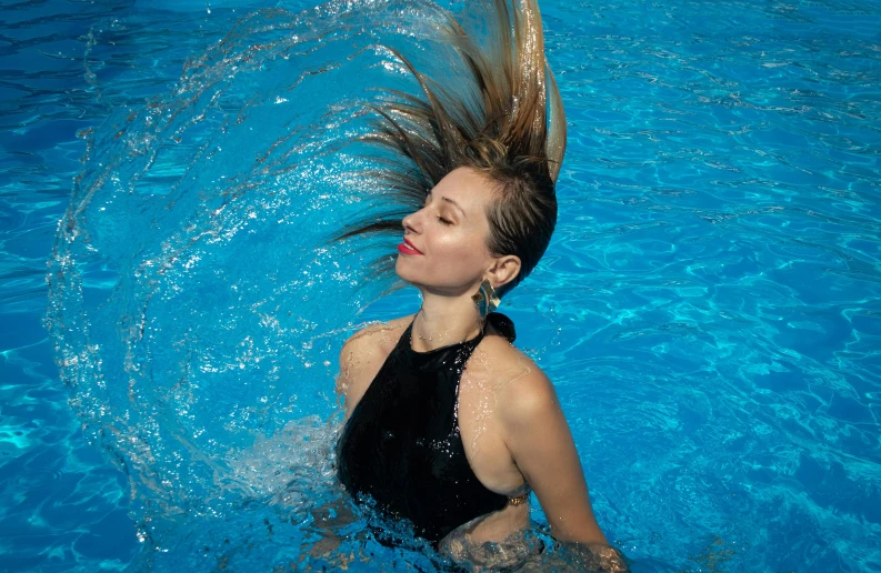 a girl with her hair in the air swimming