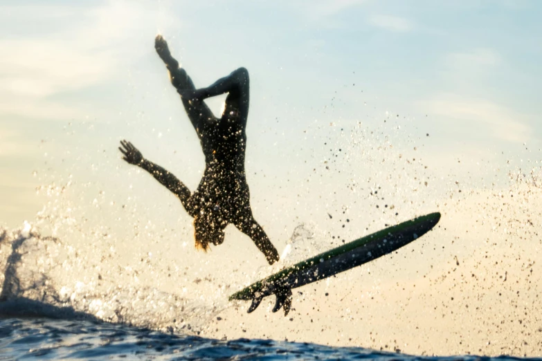 a person on a surfboard flies in the air above water