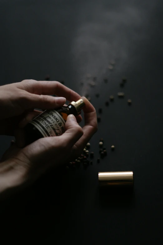 a person holding up a small jar containing some things