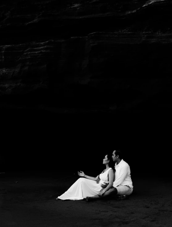 a couple sitting on the ground during their wedding portraits