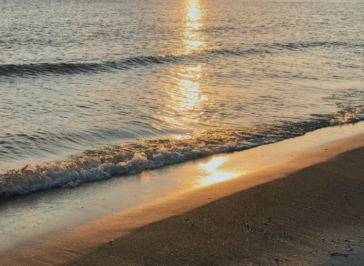 a sunset in the ocean on an ocean beach