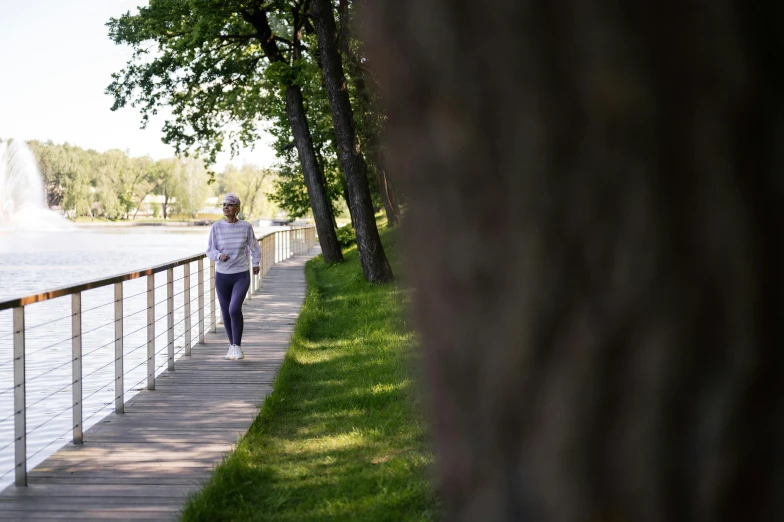 woman on the side walk at lake looking towards fountain