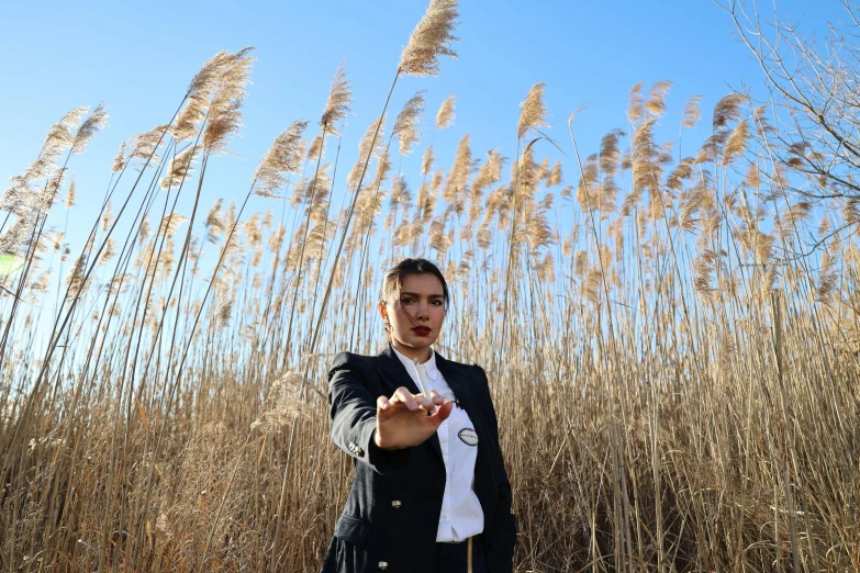 a woman standing in front of tall grass