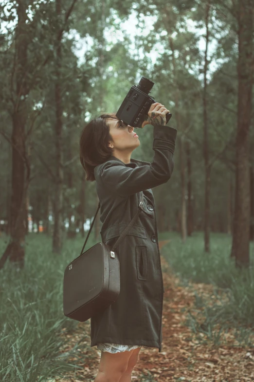 a woman taking pictures of the woods with binoculars