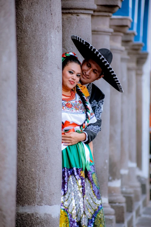 a couple in sombrero hugging in an archway