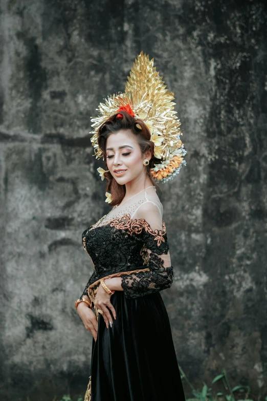 a woman wearing a black dress with feathers on top