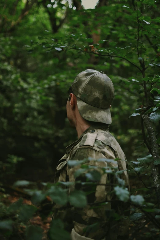 an army man looking at trees and bushes