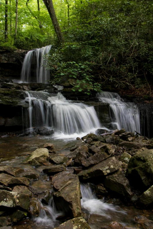 waterfall with rocks in stream and trees around