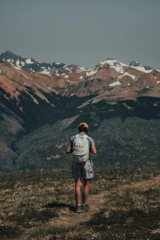 a person is on the top of a mountain with mountains in the background