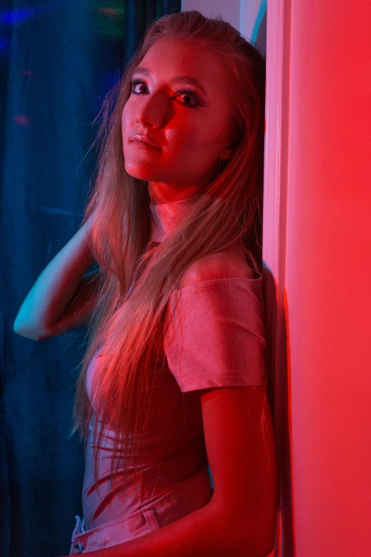 the girl is standing in front of a bright red wall