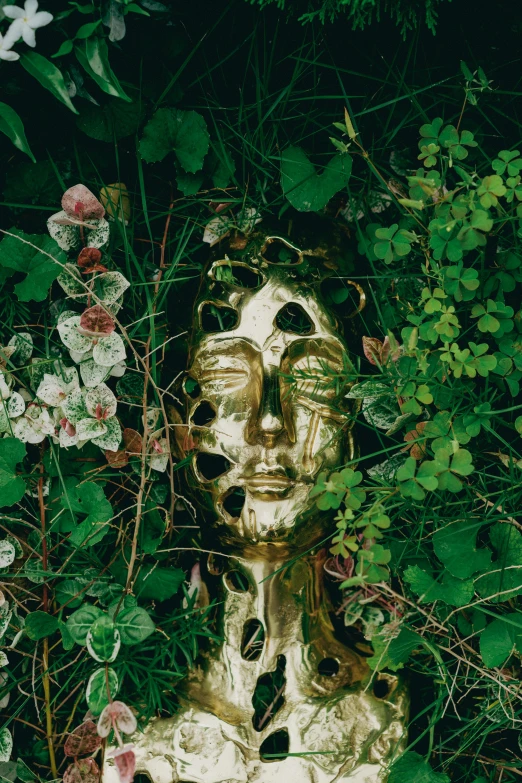 a golden statue surrounded by ivy in the forest