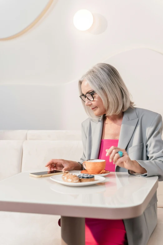 a lady wearing glasses sitting down at a table