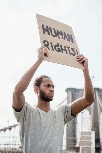 a man holding a sign with the word human rights in the air