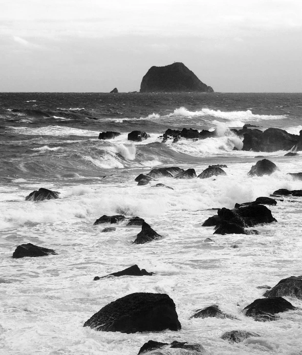 a black and white po of a beach with waves