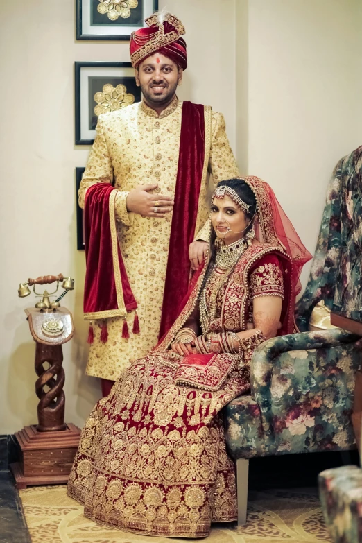 a man and woman in elaborate wedding clothes pose for a picture