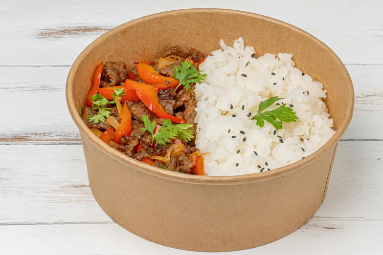 a paper container filled with meat and vegetables