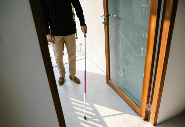 a man holding his cane in the hallway