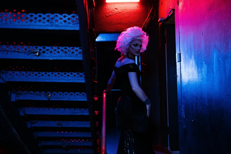 a woman in a creepy red wig next to a stairwell