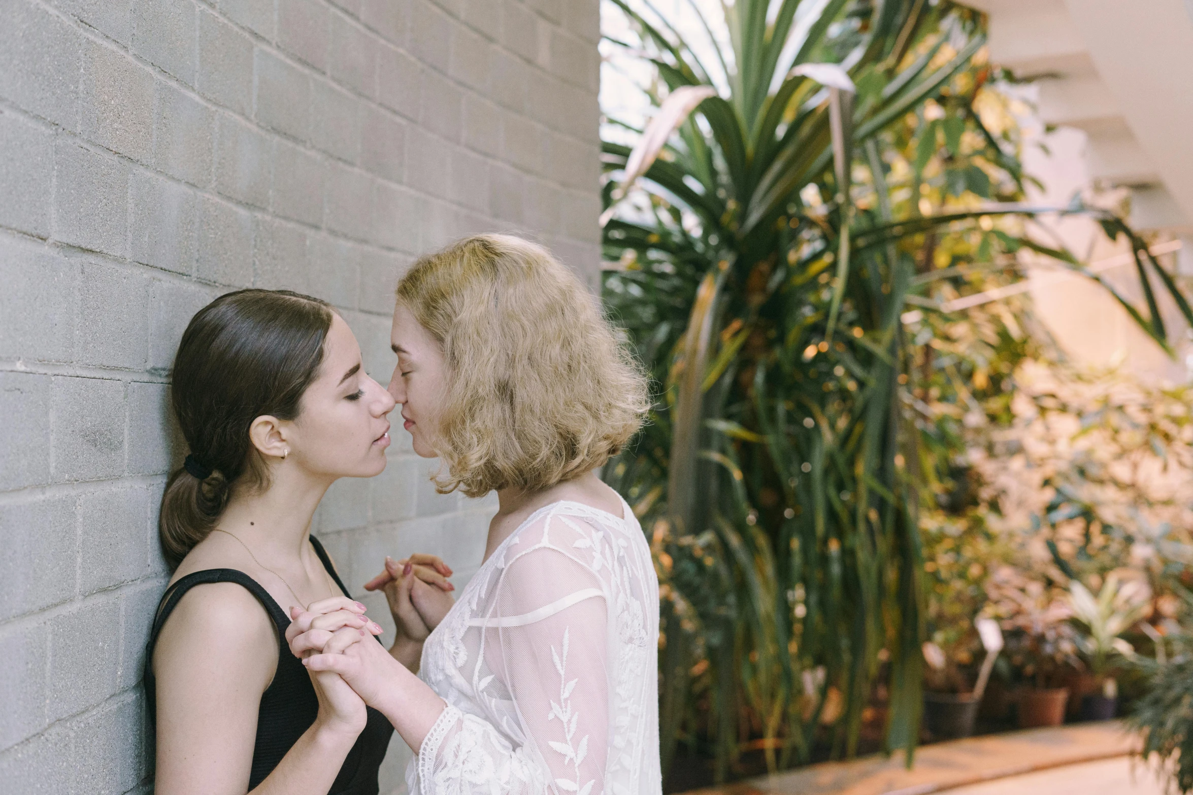 two beautiful young women standing together, emcing each other