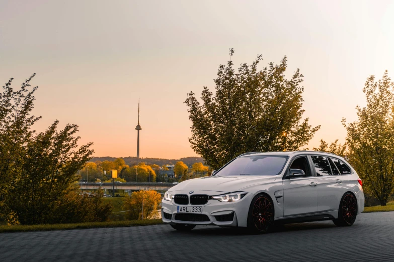 a white car with some orange rims on a road