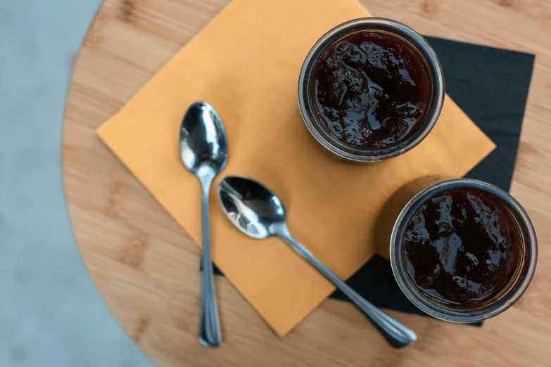 two glass jars with jam on a table