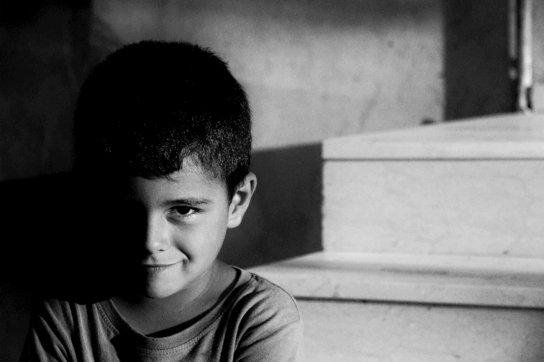 a black and white image of a boy posing for a po