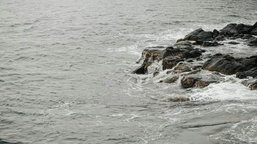 two water - filled rocks that are at the edge of the ocean