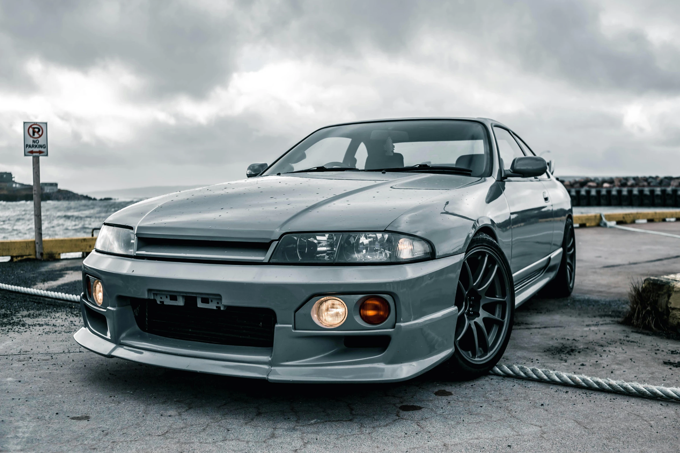 a grey toyota civic sits in front of the water