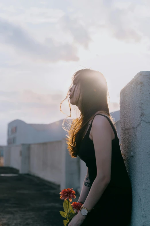 a woman standing next to a white wall