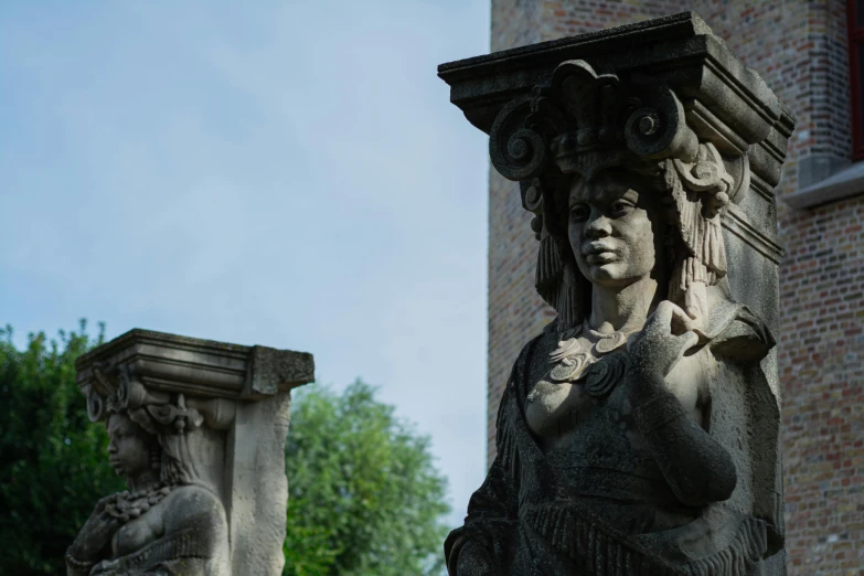 two statues stand together near a building