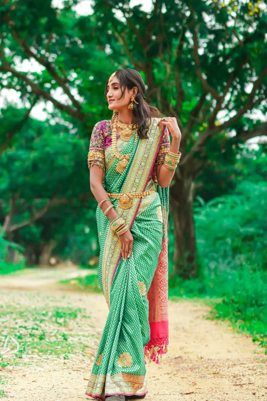 a woman with very large  in green sari posing for camera