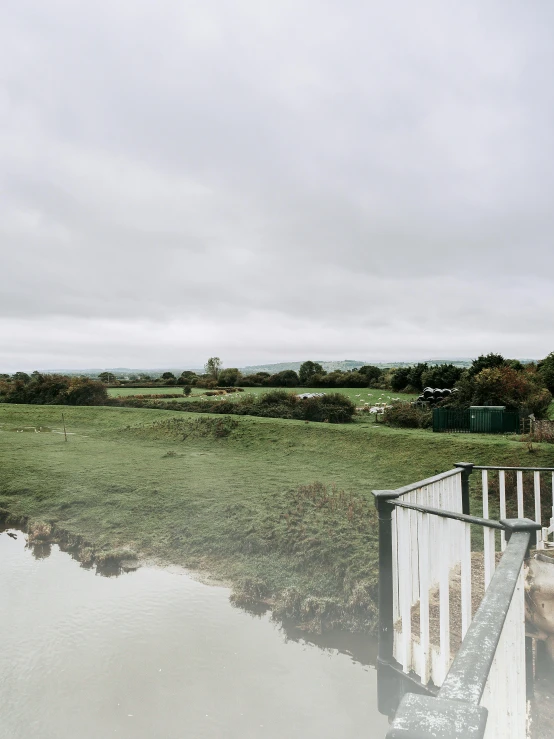 there are buildings beside the pond on a cloudy day