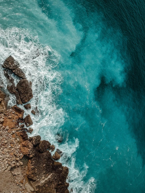 the ocean with blue water and sand in it