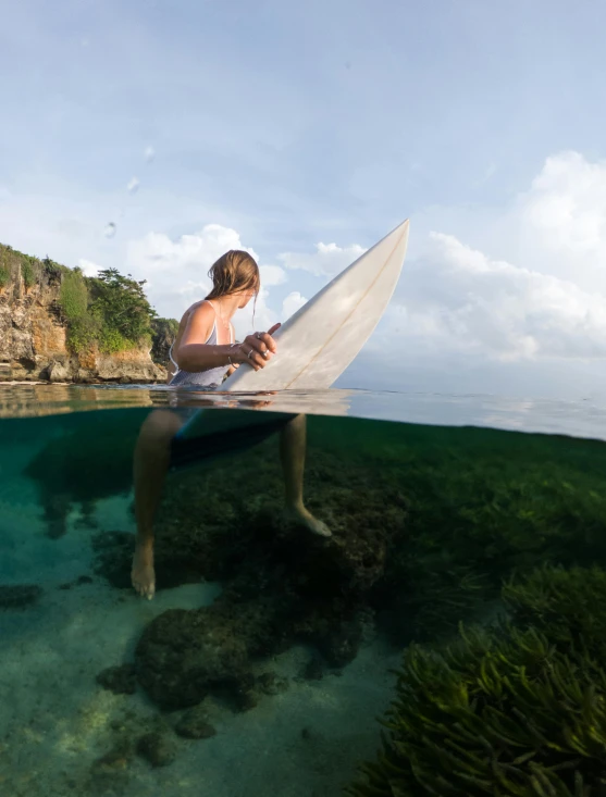 a man holds a surfboard under the water