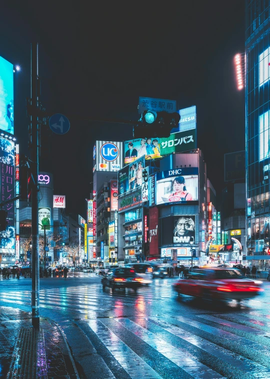 busy city with people, traffic, and neon signs at night