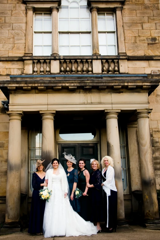 group of women standing outside of a large building together