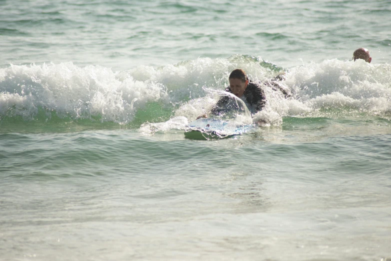 someone is laying on their stomach while riding the wave